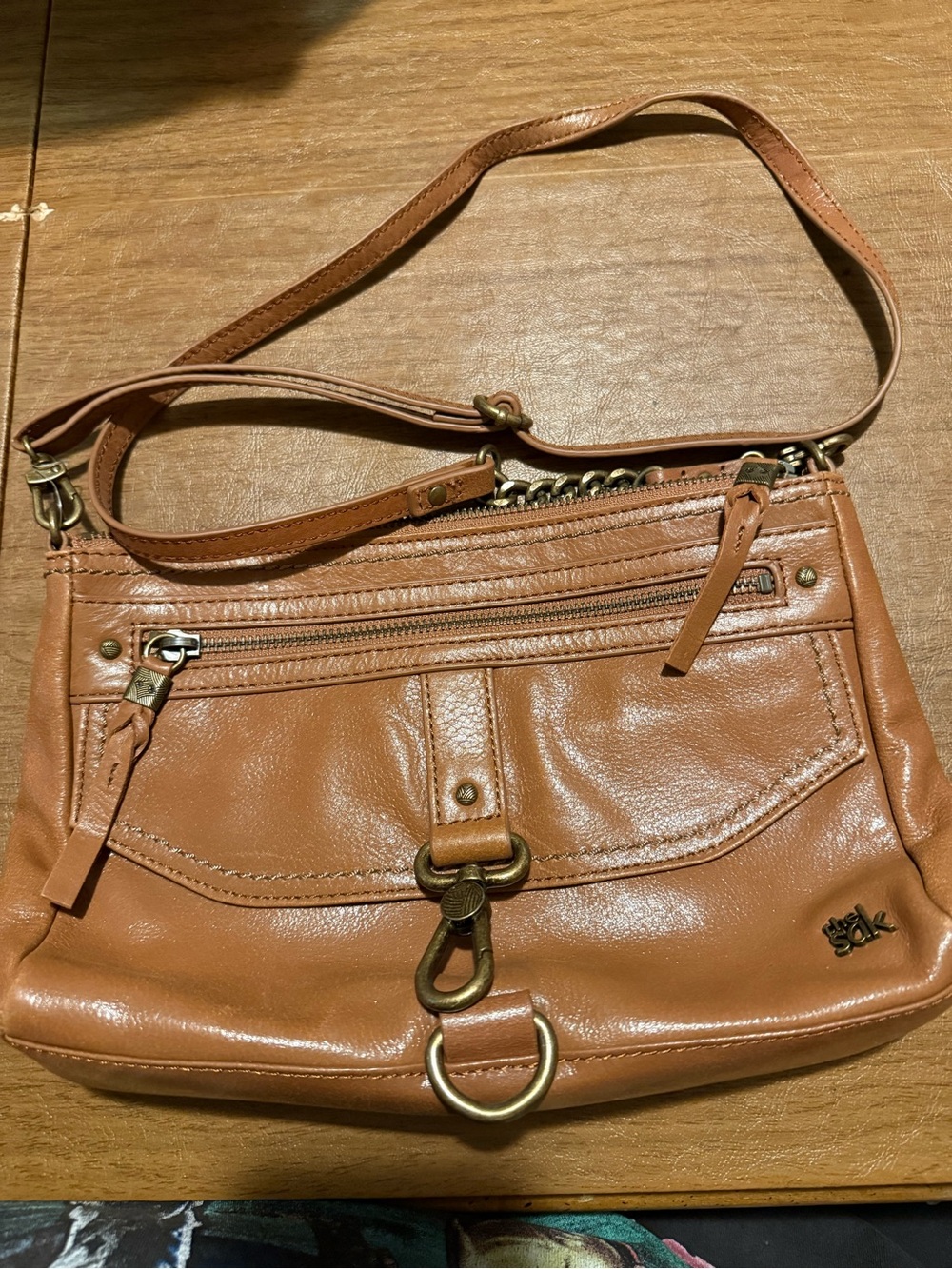 The Sak crossbody bag w/ distinctive front hook closure & brass hardware